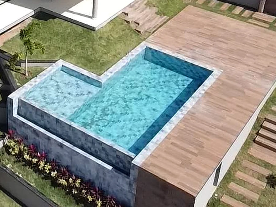 Área de lazer entregue, com piscina de borda em pedra e deck de madeira